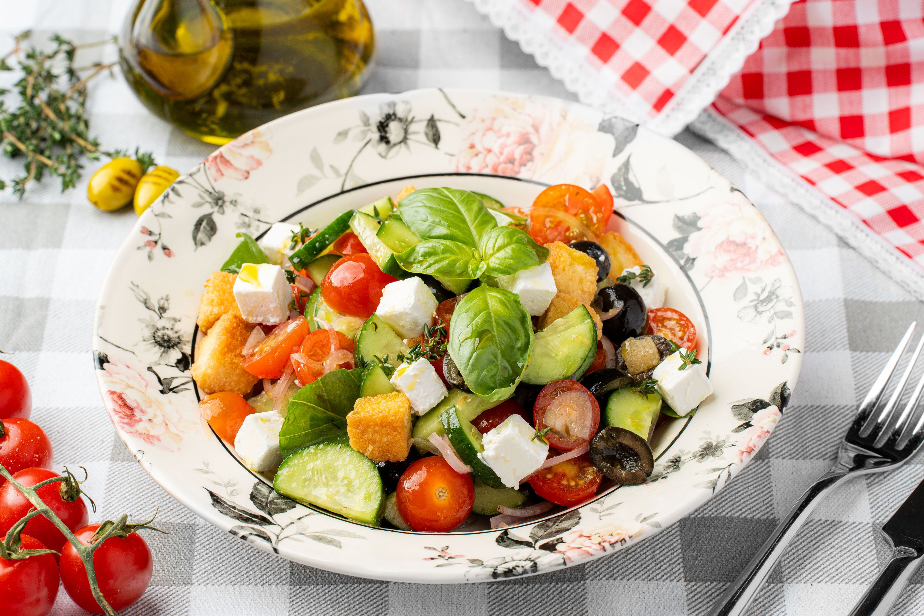 A colourful salad with leaves, tomatoes, cucumber and olives
