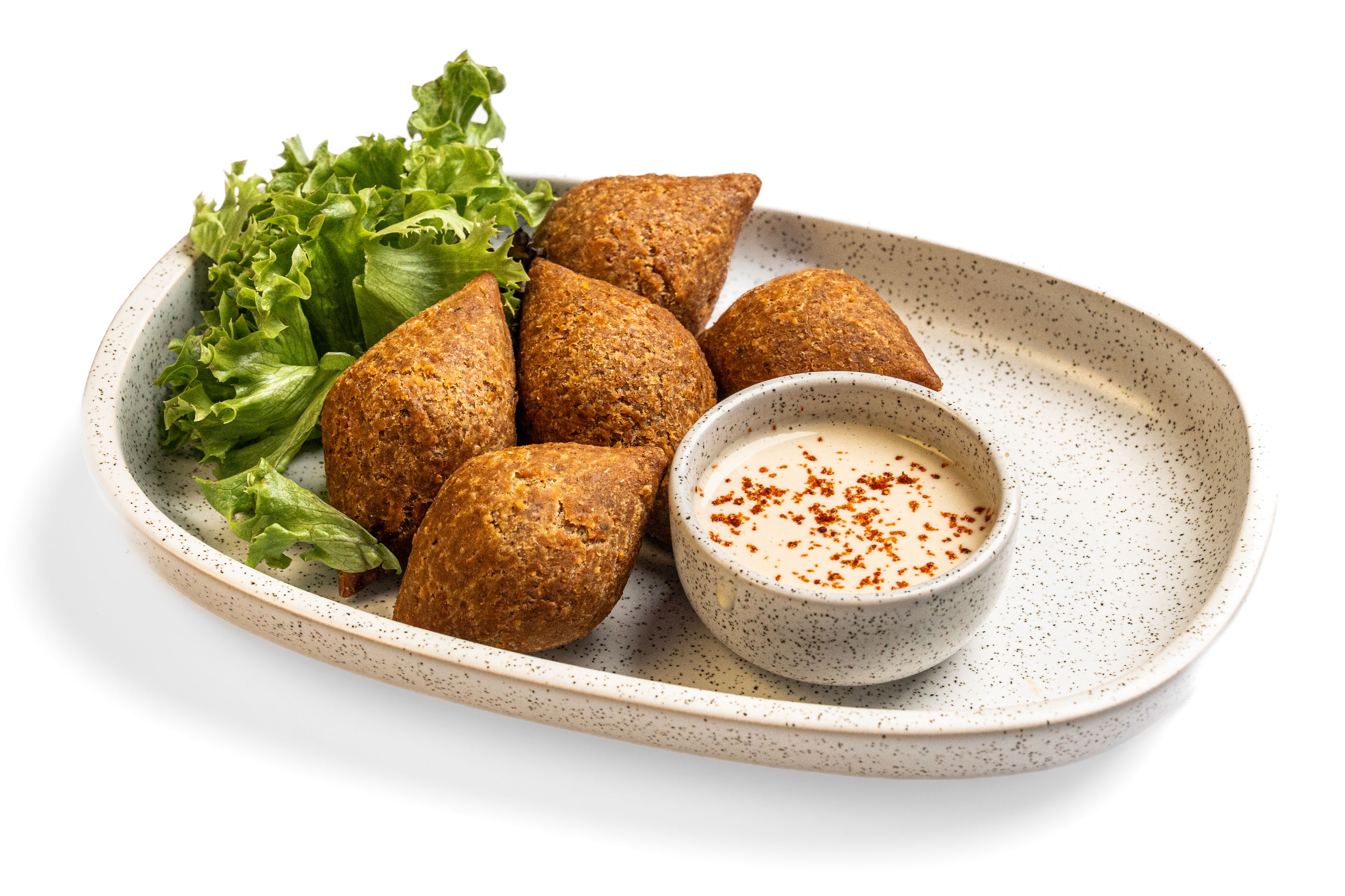 Crisp golden croquettes served with dipping sauce on a stoneware plate