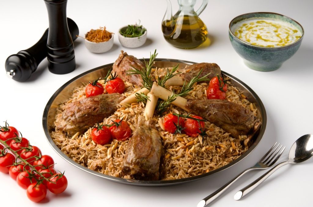 A generous platter of Lebanese lamb ouzi with lamb shanks, spiced rice, toasted nuts and tomatoes